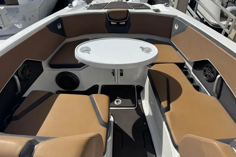 Slide: The Image of 2022 Scarab 285 ID boat interior with brown seating and round table. - 37