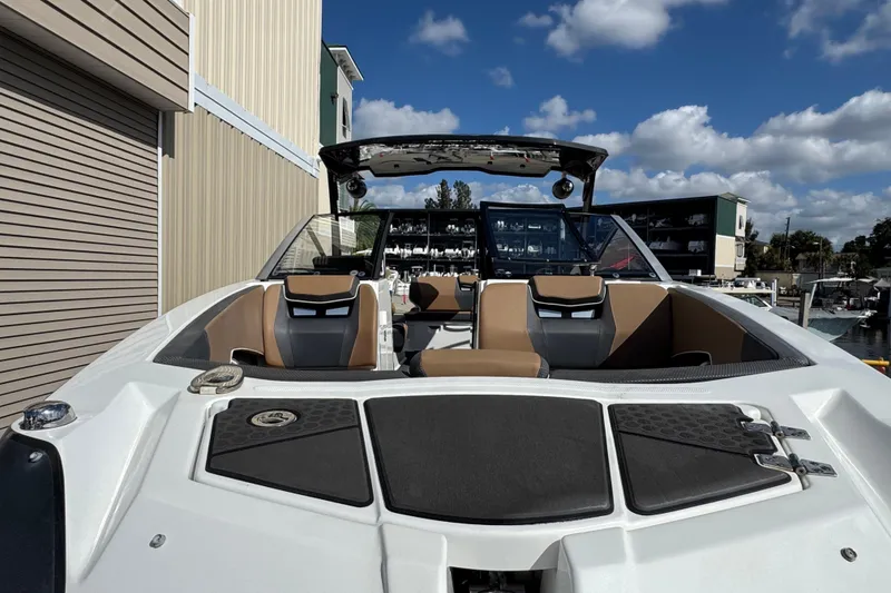 Slide: The Image of 2022 Scarab 285 ID boat interior with tan seats, docked under a blue sky. - 4