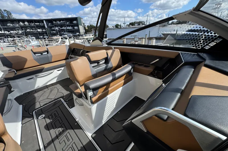 Slide: The Image of 2022 Scarab 285 ID boat interior with tan and black seating, docked at marina. - 44