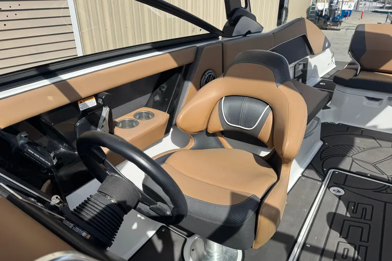 Slide: The Image of 2022 Scarab 285 ID boat interior with tan and black seating, steering wheel, and cup holders. - 46
