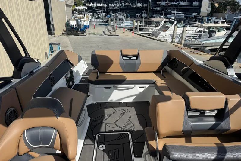 Slide: The Image of 2022 Scarab 285 ID boat interior with tan and black seating at marina. - 47
