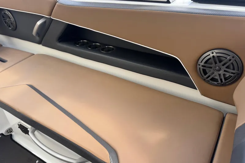 Slide: The Image of 2022 Scarab 285 ID boat interior with brown seating, cup holders, and speakers. - 51