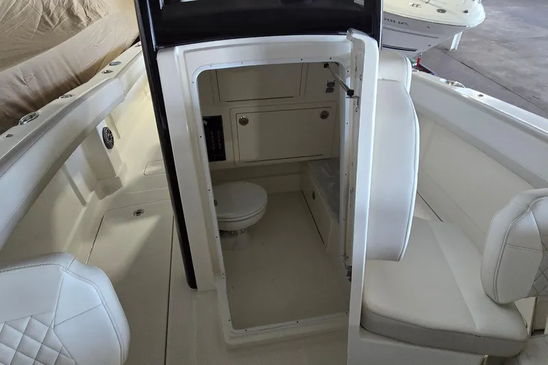 Slide: The Image of 2024 WorldCat 280 CC-X boat interior with seating and compact restroom. - 13