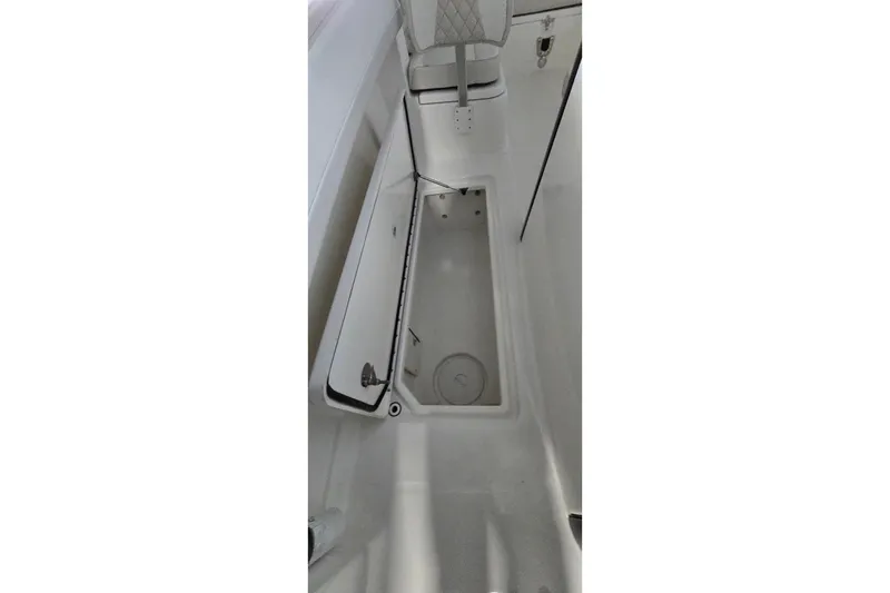 Slide: The Image of 2024 WorldCat 280 CC-X boat storage compartment with open lid, showcasing interior space. - 17