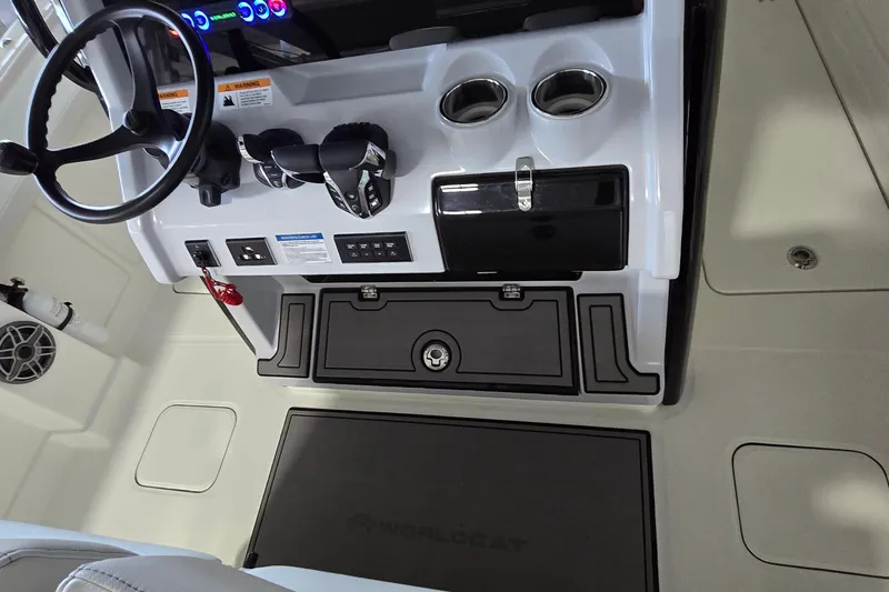 Slide: The Image of 2024 WorldCat 280 CC-X boat cockpit with steering wheel, controls, and cup holders. - 20