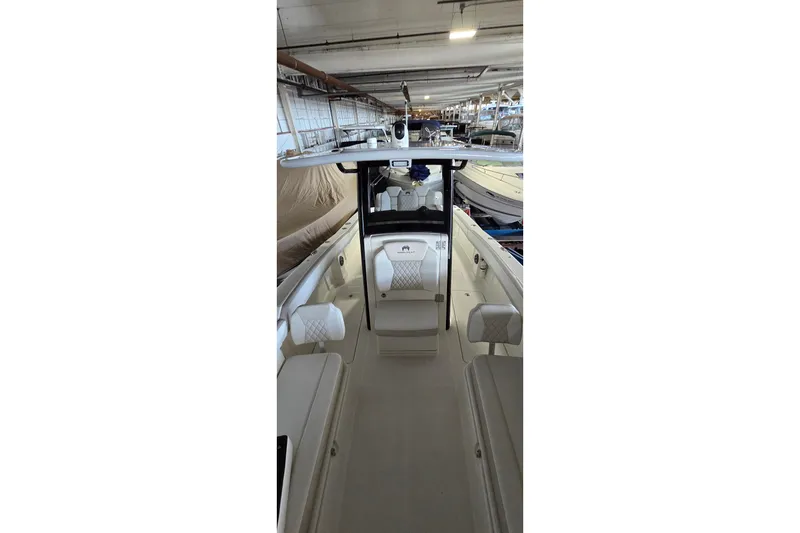 Slide: The Image of 2024 WorldCat 280 CC-X boat interior with seating and helm in a storage facility. - 34