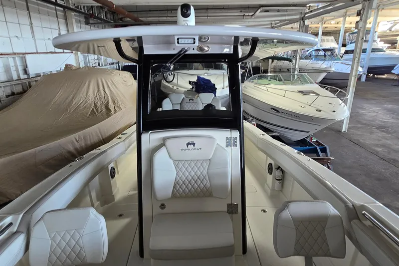 Slide: The Image of 2024 WorldCat 280 CC-X boat interior in a storage facility, showcasing seating and helm. - 9