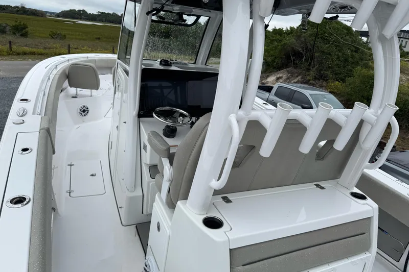 Slide: The Image of 2021 Sportsman Open 322 Center Console boat interior with rod holders and steering console. - 12