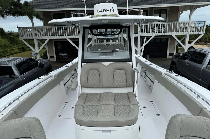 Slide: The Image of 2021 Sportsman Open 322 Center Console boat with cushioned seating and Garmin equipment. - 18