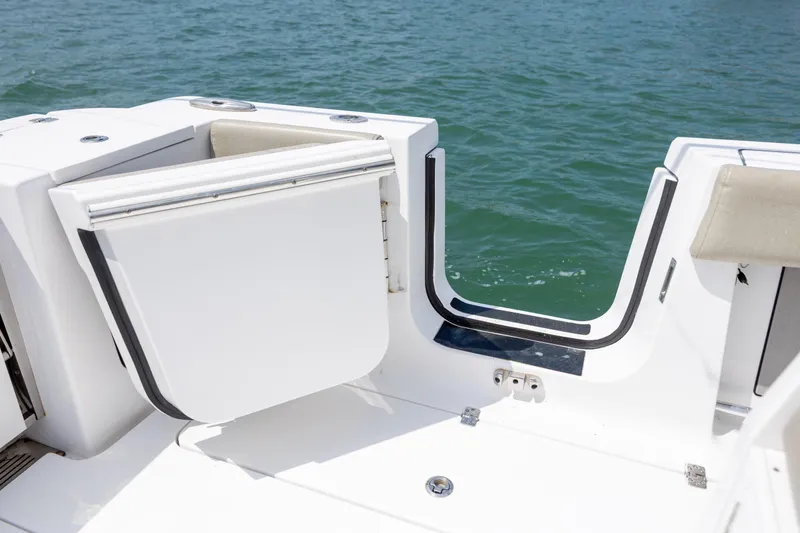 Slide: The Image of 2021 Sportsman Open 322 Center Console boat with open side door on water. - 23