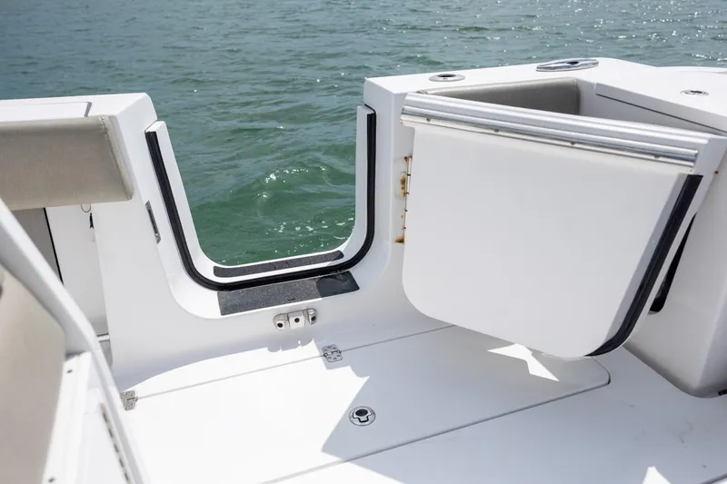Slide: The Image of 2021 Sportsman Open 322 Center Console boat with open side door on water. - 24