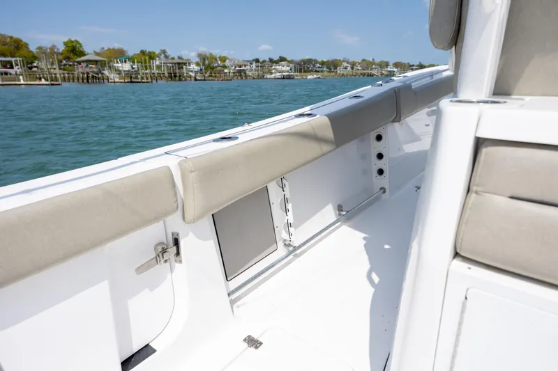 Slide: The Image of 2021 Sportsman Open 322 Center Console boat interior with cushioned seating, dockside view. - 27