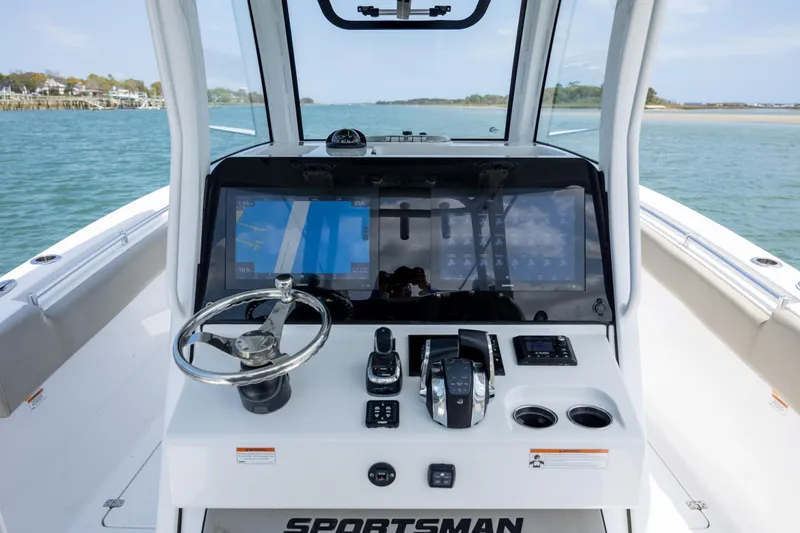 Slide: The Image of 2021 Sportsman Open 322 Center Console boat dashboard with steering wheel and navigation screens. - 31