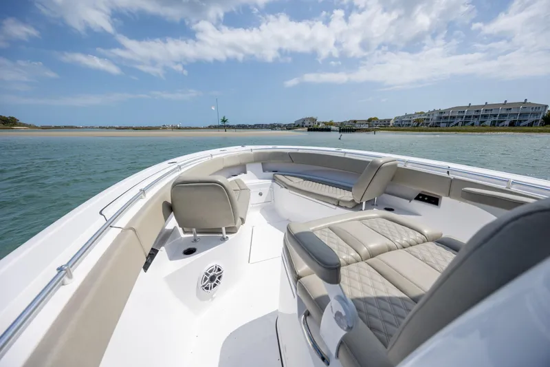 Slide: The Image of 2021 Sportsman Open 322 Center Console boat interior with luxurious seating on calm water. - 38
