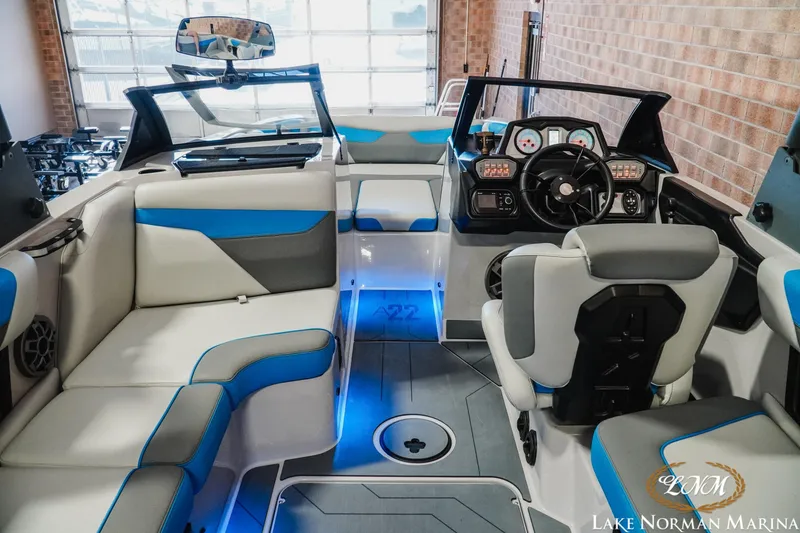 Slide: The Image of 2021 Axis A22 boat interior with blue accents, modern dashboard, and comfortable seating. - 10