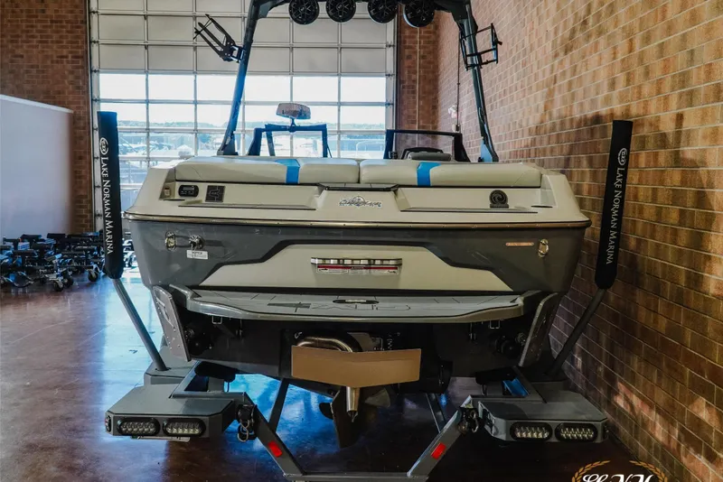 Slide: The Image of 2021 Axis A22 boat in showroom, rear view with wakeboard tower and Lake Norman Marina branding. - 7