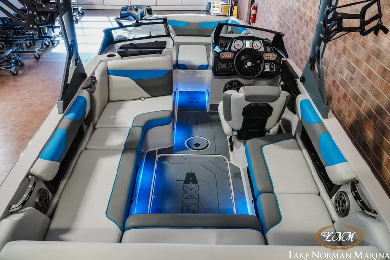 Slide: The Image of 2021 Axis A22 boat interior with blue accents, modern dashboard, and spacious seating. - 9