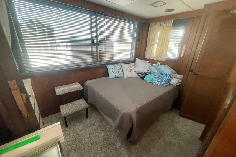 Slide: The Image of Cozy bedroom in 1991 Gibson 37 Houseboat with wood paneling and large windows. - 2