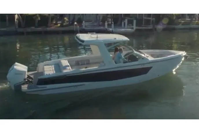 Slide: The Image of 2023 Aviara AV32 OB boat cruising on a calm waterway with scenic background. - 0