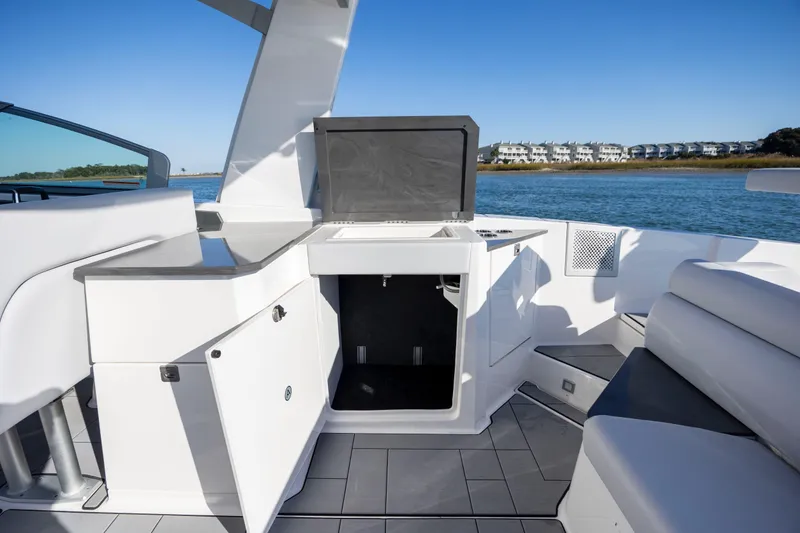 Slide: The Image of 2023 Aviara AV32 OB boat interior with open storage, sleek design, and waterfront view. - 19