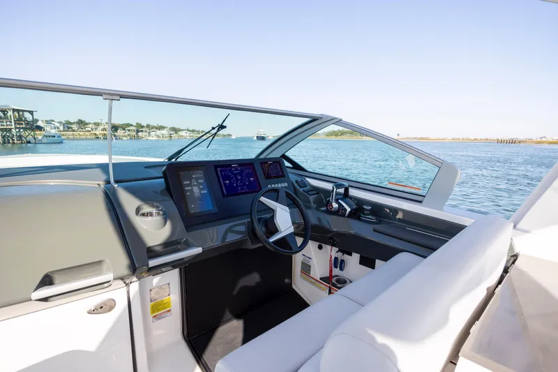 Slide: The Image of 2023 Aviara AV32 OB boat cockpit with modern controls and scenic water view. - 21