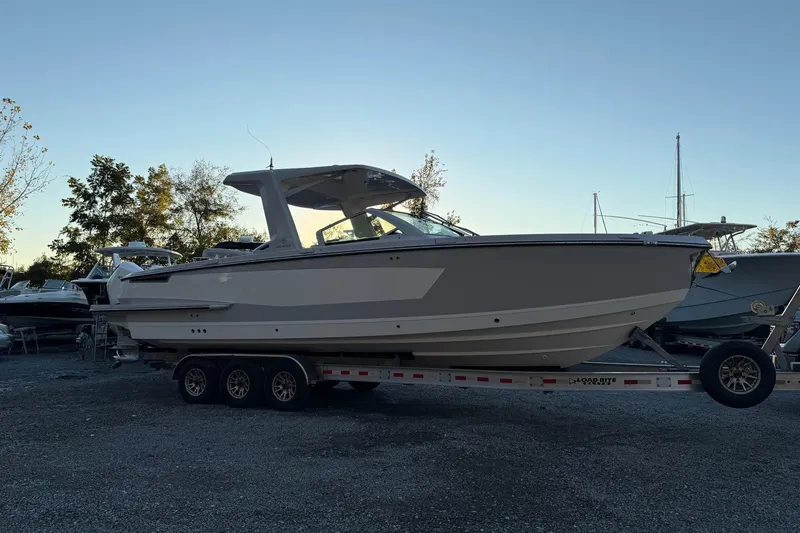Slide: The Image of 2023 Aviara AV32 OB boat on trailer, parked outdoors at sunset. - 33