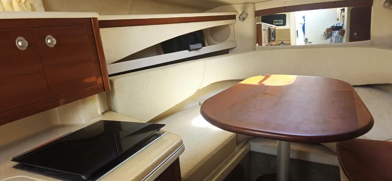 Slide: The Image of Interior of 2008 Sea Ray 260 Sundancer with wooden table and seating area. - 15