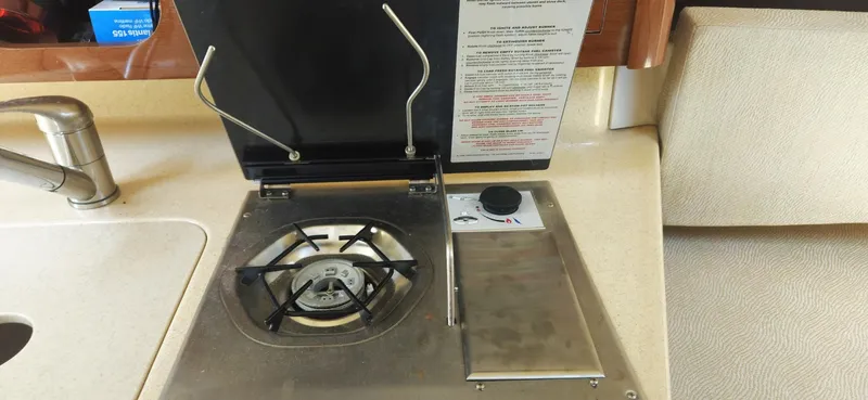 Slide: The Image of Compact kitchen area with stove and sink on 2008 Sea Ray 260 Sundancer boat. - 23