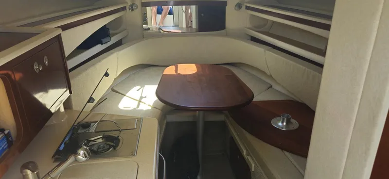 Slide: The Image of 2008 Sea Ray 260 Sundancer cabin interior with dining table and compact kitchen area. - 14