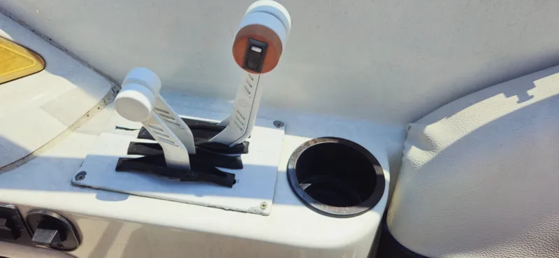 Slide: The Image of Boat throttle controls on a 1999 Cobalt 293, featuring dual levers and a cup holder. - 5