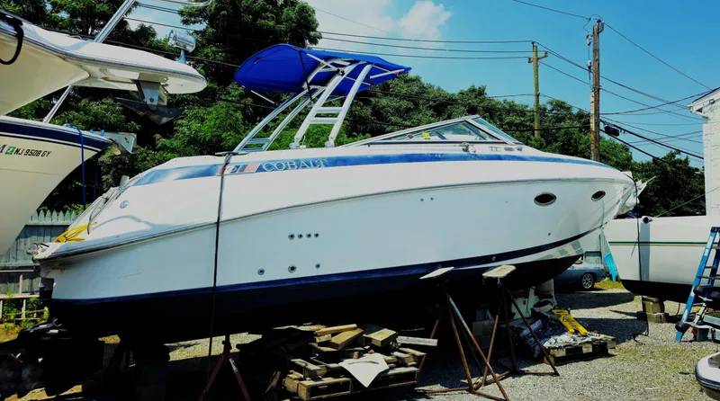 The Image of 1999 Cobalt 293 boat on stands, blue canopy, outdoor storage. - 0