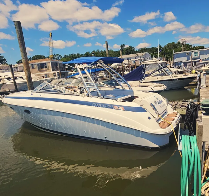 Slide: The Image of 1999 Cobalt 293 boat docked at marina under blue sky. - 2