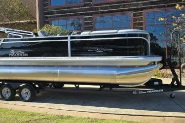 The Image of 2026 Sun Tracker Party Barge 22 RF XP3 pontoon boat on trailer, parked outdoors. - 0