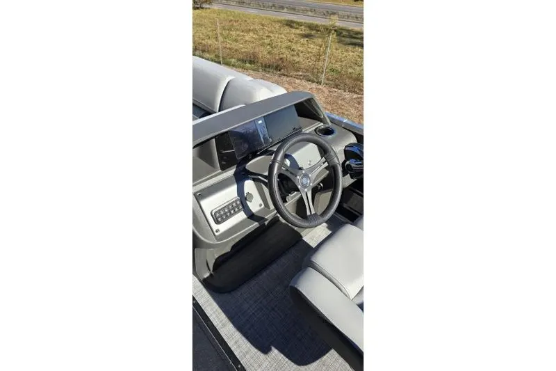 Slide: The Image of 2026 Sun Tracker Party Barge 22 RF XP3 steering console with modern controls and seating. - 12
