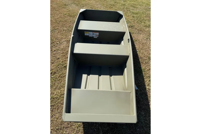 Slide: The Image of 2026 Tracker Grizzly 10 Jon boat on grass, showcasing interior seating and design. - 5