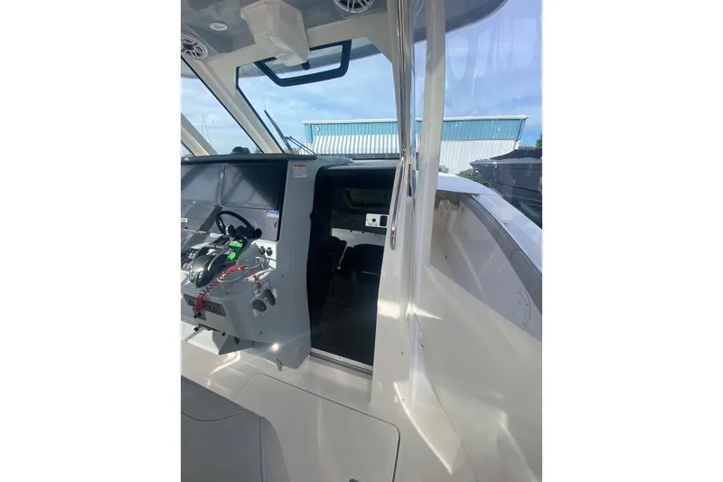 Slide: The Image of 2024 Pursuit S 328 Sport boat cockpit with modern controls and steering wheel. - 11
