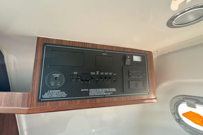 Slide: The Image of 2024 Pursuit S 328 Sport control panel with switches and outlets in cabin. - 15