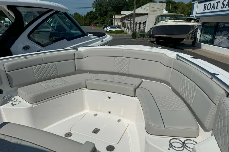 Slide: The Image of 2024 Pursuit S 328 Sport boat with spacious, cushioned seating in a showroom setting. - 16
