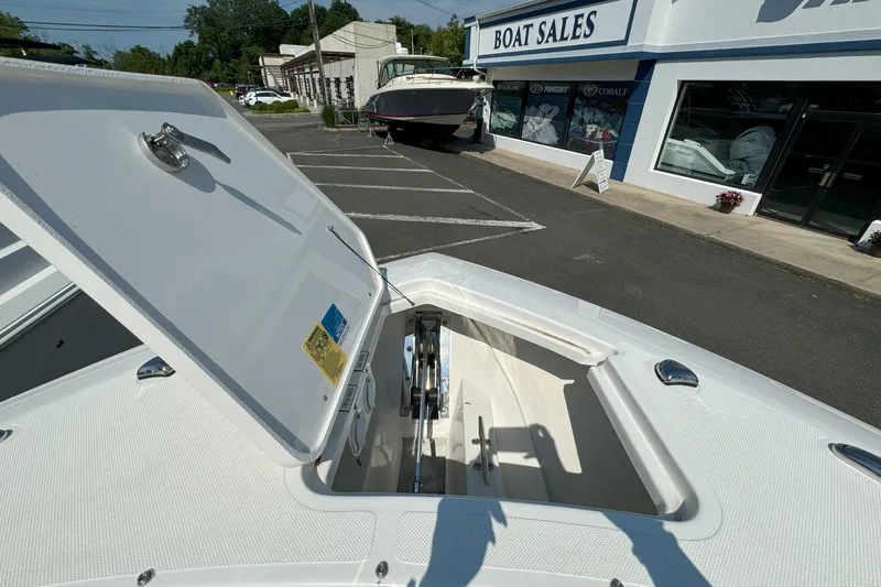 Slide: The Image of 2024 Pursuit S 328 Sport boat at dealership with open storage compartment. - 18