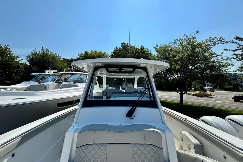 Slide: The Image of 2024 Pursuit S 328 Sport boat, sleek design, docked outdoors under clear blue sky. - 20
