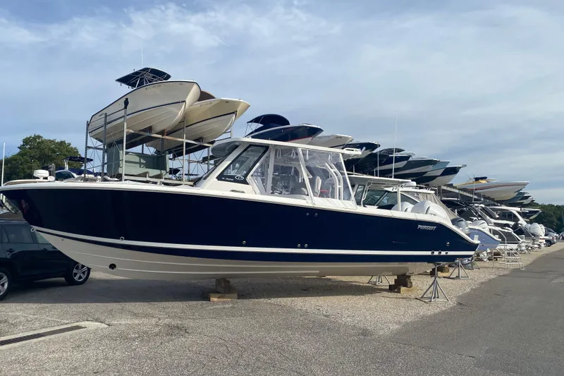 Slide: The Image of 2024 Pursuit S 328 Sport boat displayed in a marina, surrounded by other vessels. - 3