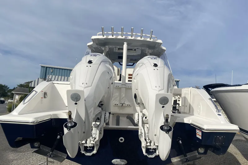 Slide: The Image of 2024 Pursuit S 328 Sport boat with dual outboard engines, docked under a clear sky. - 4