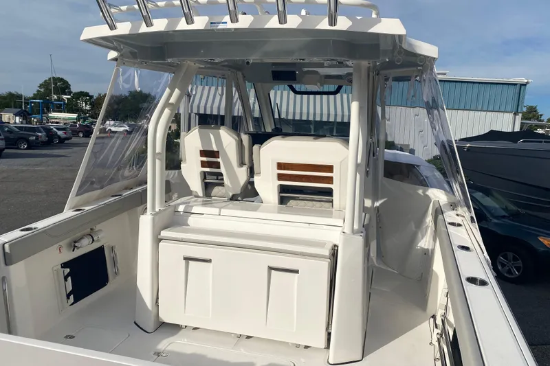 Slide: The Image of 2024 Pursuit S 328 Sport boat interior with seating and storage, docked outdoors. - 5