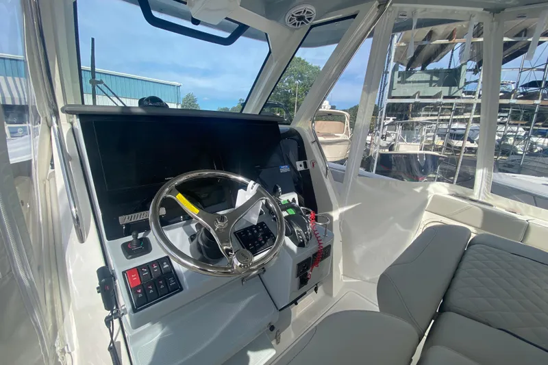 Slide: The Image of 2024 Pursuit S 328 Sport boat cockpit with steering wheel and control panel. - 8