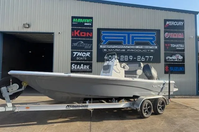 The Image of 2025 NauticStar 214 Bay boat on trailer outside marine shop. - 0