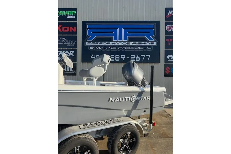 Slide: The Image of 2025 NauticStar 214 Bay boat on trailer at marine dealership. - 1