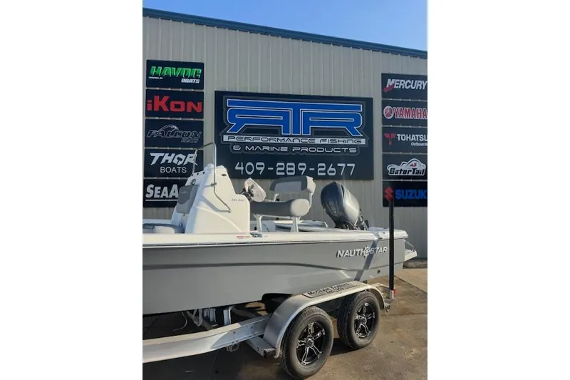 Slide: The Image of 2025 NauticStar 214 Bay boat on trailer at marine dealership. - 3
