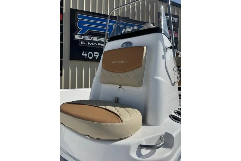 Slide: The Image of 2025 NauticStar 214 Shallow Bay boat interior with tan seating and console. - 4