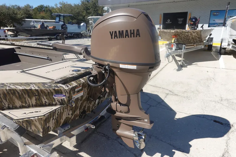 Slide: The Image of Avid 16 Commander 2026 boat with Yamaha outboard motor, camo design, parked outdoors. - 17