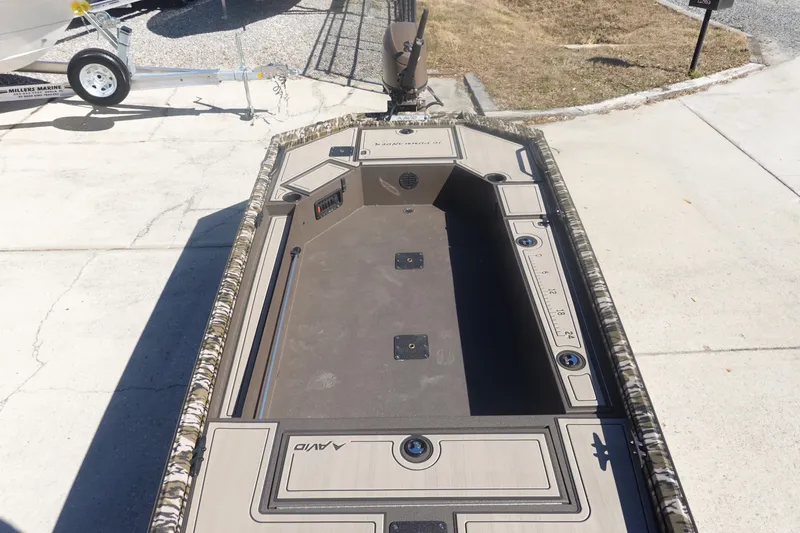 Slide: The Image of 2026 Avid 16 Commander boat with camo trim, parked on concrete driveway. - 29